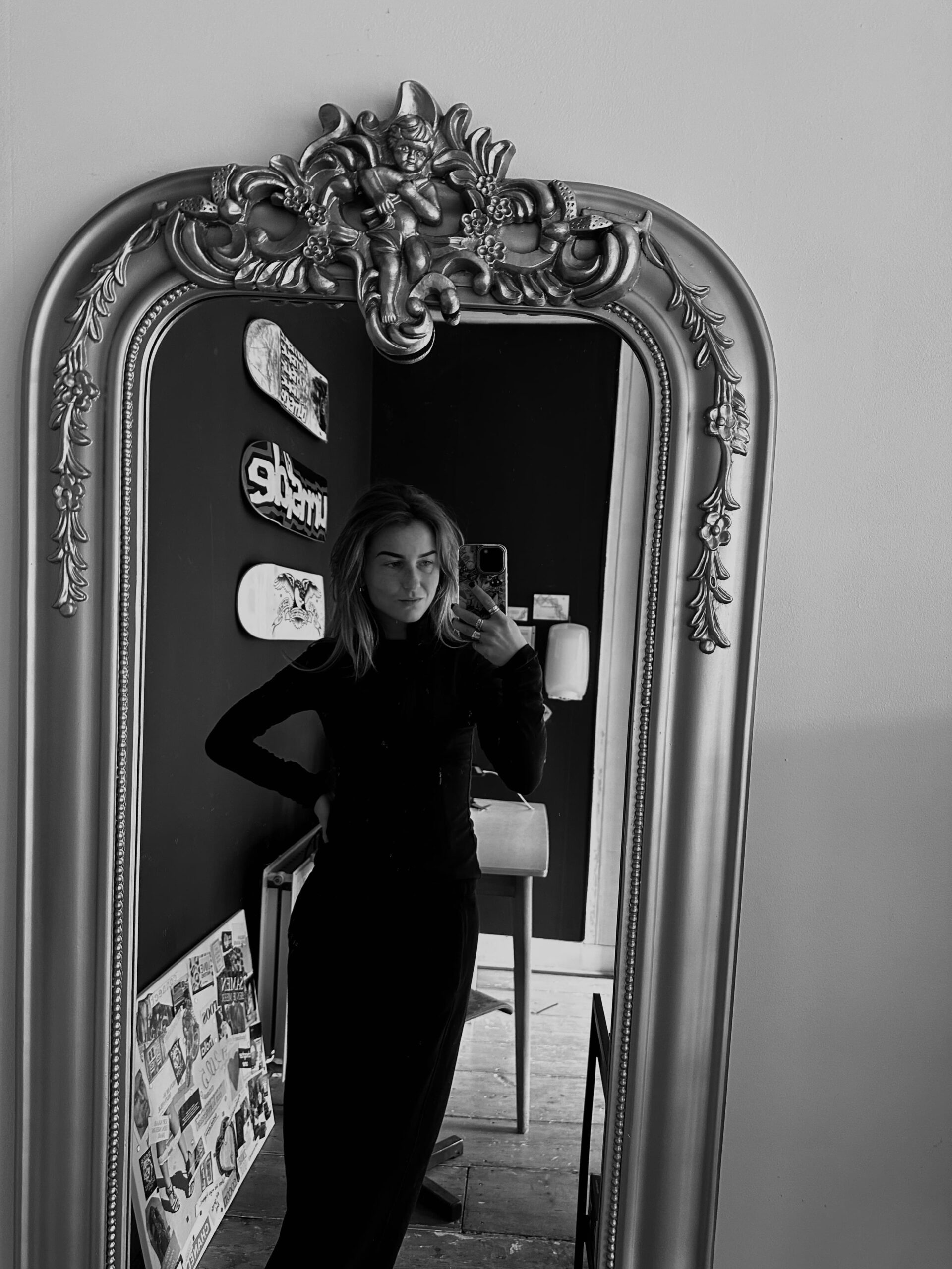 Stijlvolle vrouw die zichzelf fotografeert in een decoratief zilveren spiegel.